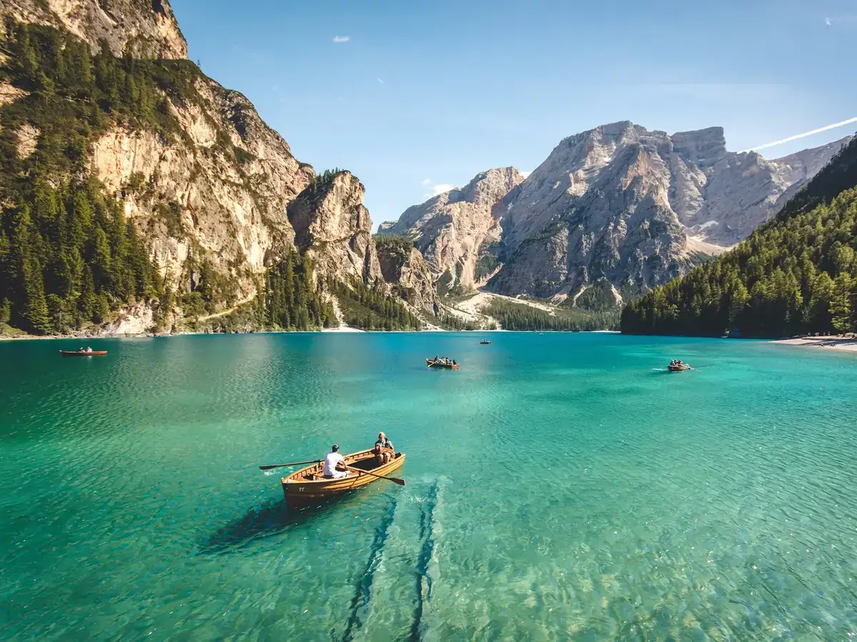 Turquoise alpine lake with a rowing boat and mountains for a travel app